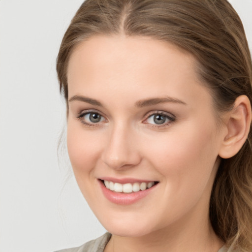 Joyful white young-adult female with long  brown hair and blue eyes