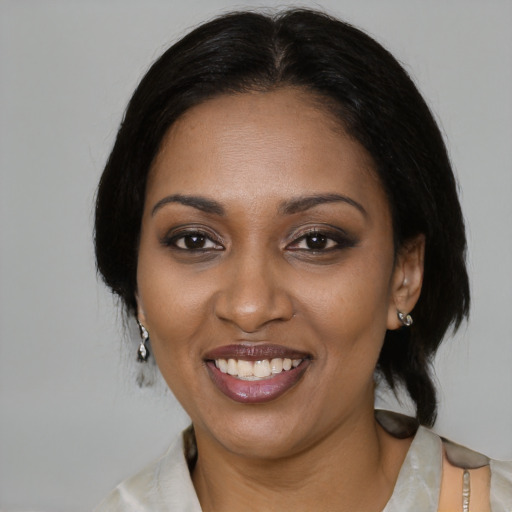 Joyful black adult female with medium  black hair and brown eyes