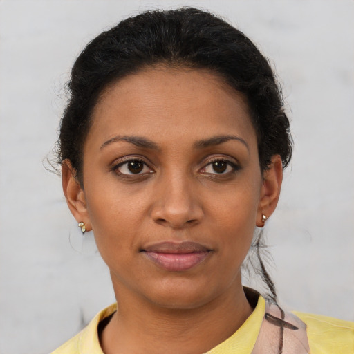 Joyful black young-adult female with short  brown hair and brown eyes