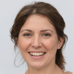 Joyful white adult female with medium  brown hair and grey eyes