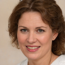 Joyful white adult female with medium  brown hair and green eyes