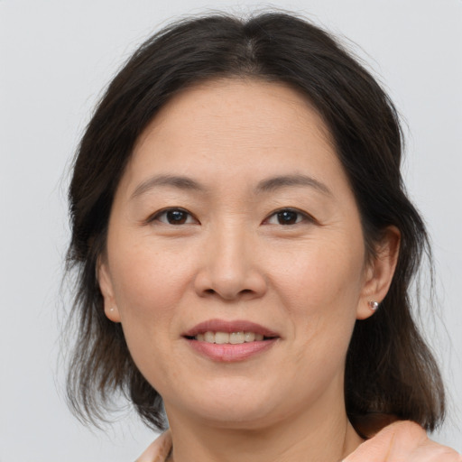 Joyful white adult female with medium  brown hair and brown eyes