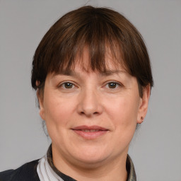 Joyful white adult female with medium  brown hair and grey eyes