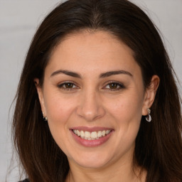 Joyful white adult female with long  brown hair and brown eyes