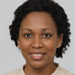 Joyful black adult female with short  black hair and brown eyes