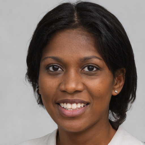 Joyful black young-adult female with medium  brown hair and brown eyes