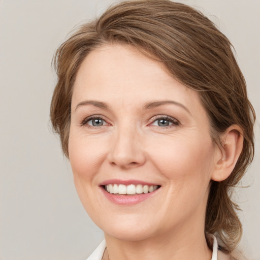 Joyful white young-adult female with medium  brown hair and grey eyes