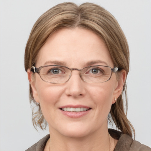 Joyful white adult female with medium  brown hair and blue eyes