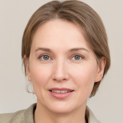 Joyful white adult female with medium  brown hair and grey eyes