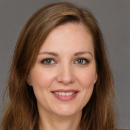 Joyful white young-adult female with long  brown hair and brown eyes