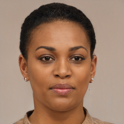 Joyful black young-adult female with short  black hair and brown eyes