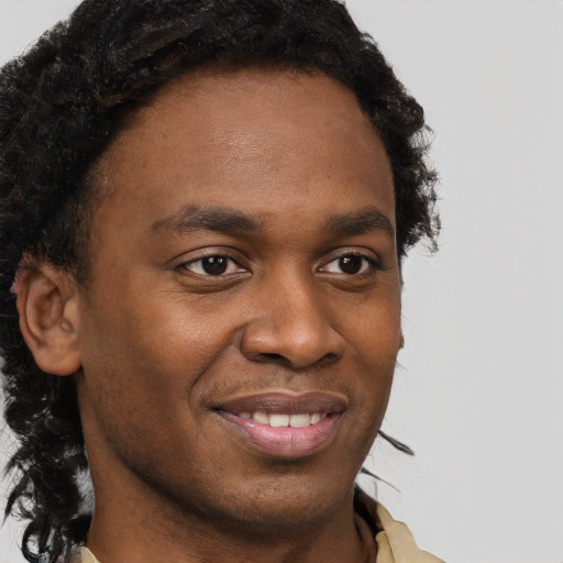 Joyful black young-adult male with short  brown hair and brown eyes