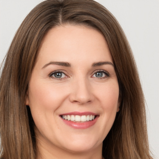 Joyful white young-adult female with long  brown hair and brown eyes