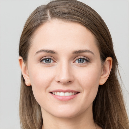 Joyful white young-adult female with long  brown hair and grey eyes