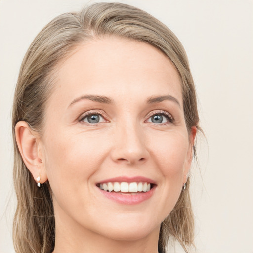 Joyful white young-adult female with long  brown hair and blue eyes