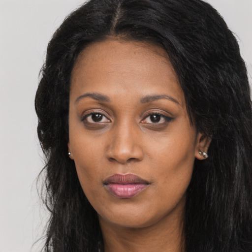 Joyful black young-adult female with long  black hair and brown eyes