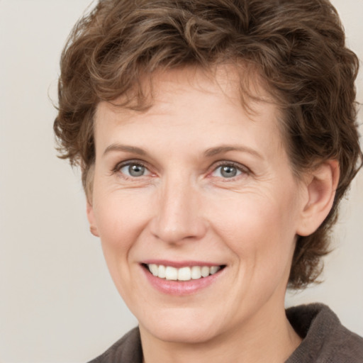 Joyful white adult female with medium  brown hair and grey eyes