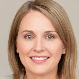 Joyful white young-adult female with medium  brown hair and green eyes