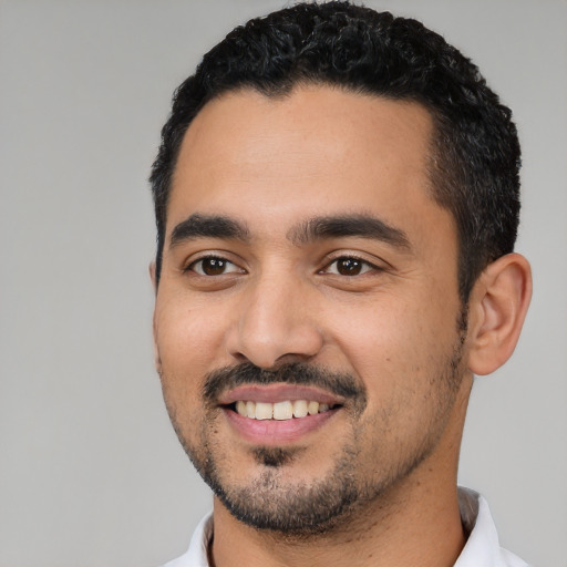 Joyful latino young-adult male with short  black hair and brown eyes