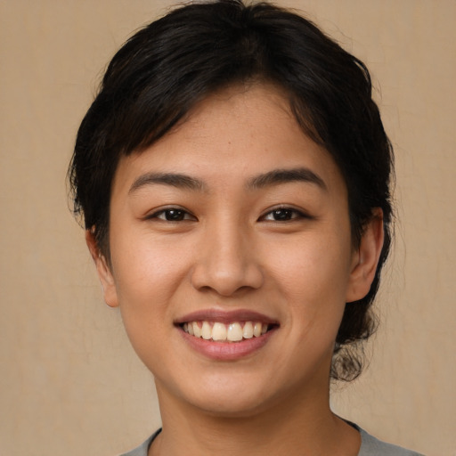 Joyful asian young-adult female with short  brown hair and brown eyes