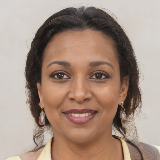 Joyful latino young-adult female with medium  brown hair and brown eyes