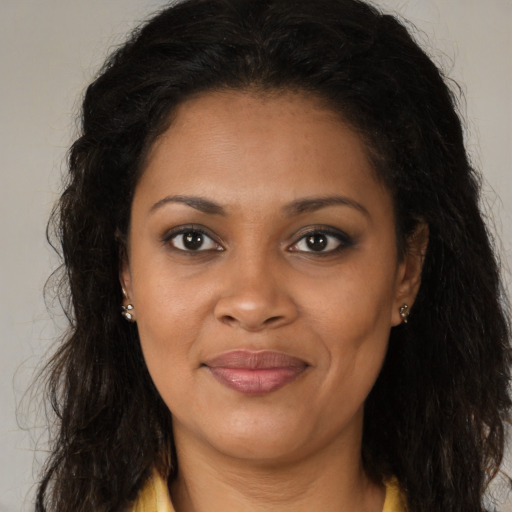 Joyful black young-adult female with long  brown hair and brown eyes