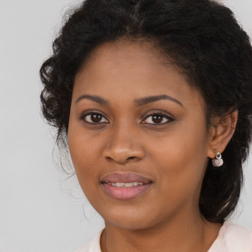 Joyful black young-adult female with long  brown hair and brown eyes