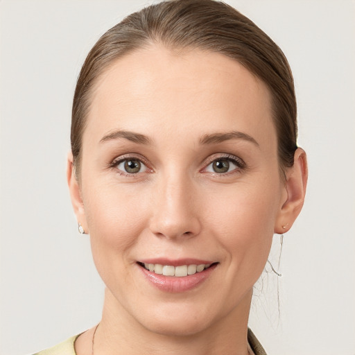 Joyful white young-adult female with medium  brown hair and grey eyes