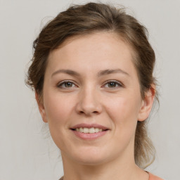 Joyful white young-adult female with medium  brown hair and grey eyes