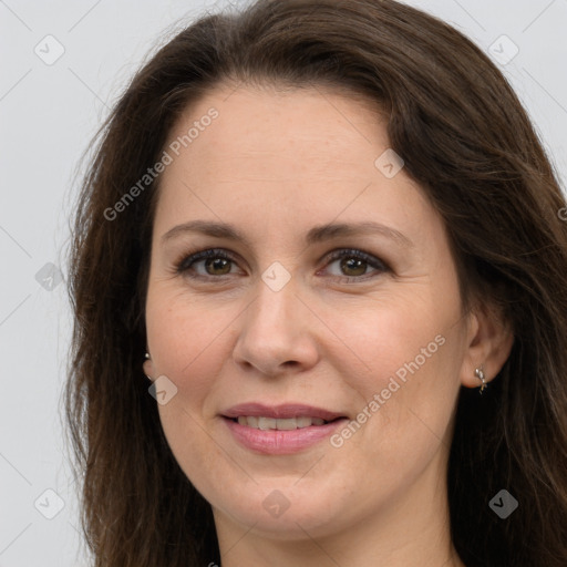 Joyful white adult female with long  brown hair and grey eyes