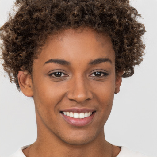 Joyful black young-adult female with short  brown hair and brown eyes