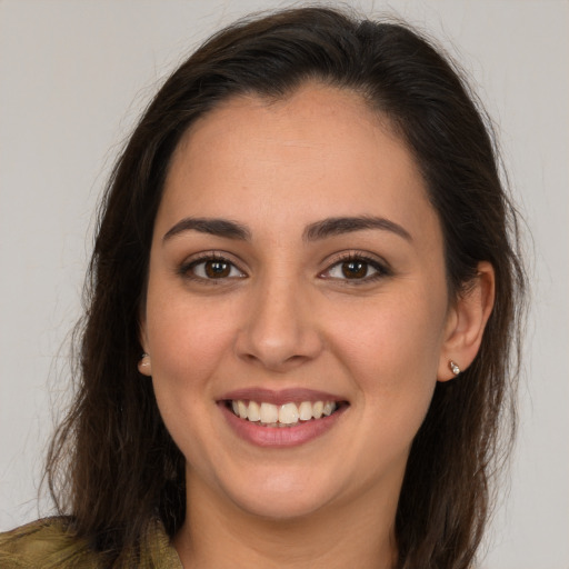 Joyful white young-adult female with long  brown hair and brown eyes