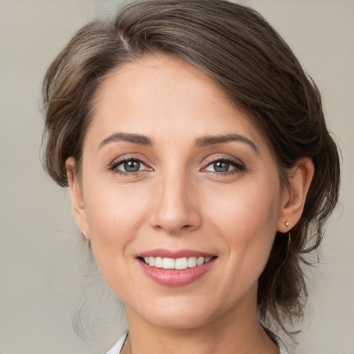 Joyful white young-adult female with medium  brown hair and grey eyes