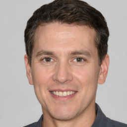 Joyful white adult male with short  brown hair and grey eyes