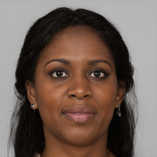 Joyful black young-adult female with long  brown hair and brown eyes