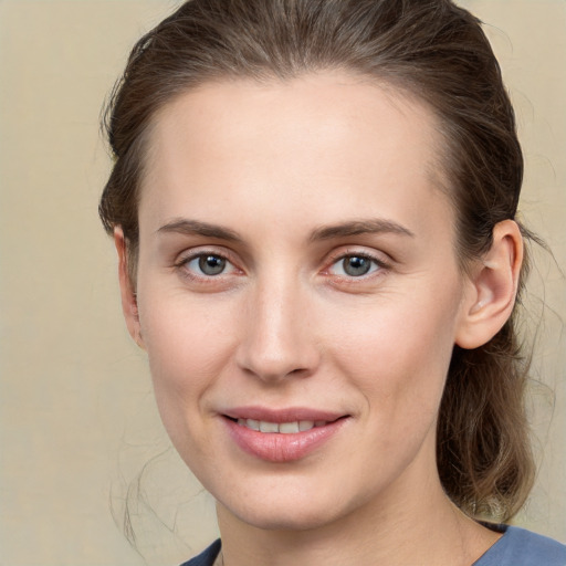 Joyful white young-adult female with medium  brown hair and grey eyes