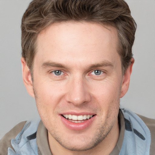 Joyful white adult male with short  brown hair and grey eyes