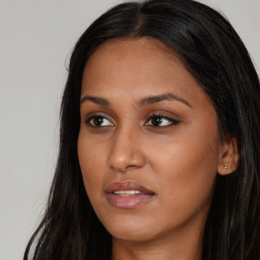 Joyful black young-adult female with long  brown hair and brown eyes