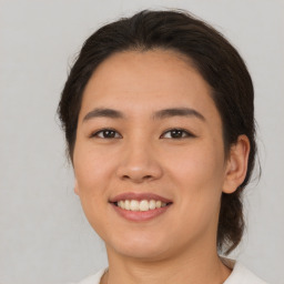 Joyful latino young-adult female with medium  brown hair and brown eyes