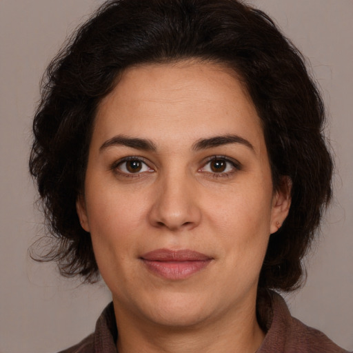 Joyful white adult female with medium  brown hair and brown eyes