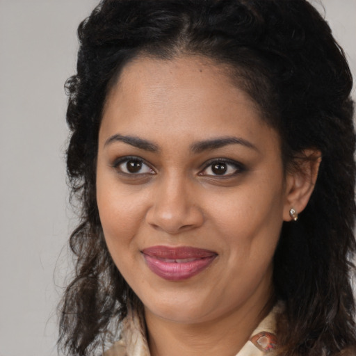 Joyful black young-adult female with long  brown hair and brown eyes