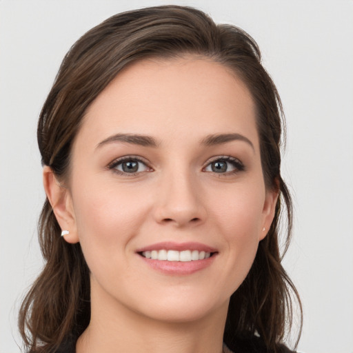 Joyful white young-adult female with long  brown hair and grey eyes