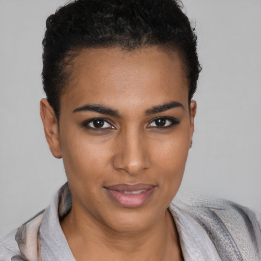 Joyful black young-adult female with short  brown hair and brown eyes