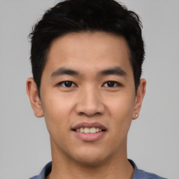 Joyful asian young-adult male with short  black hair and brown eyes