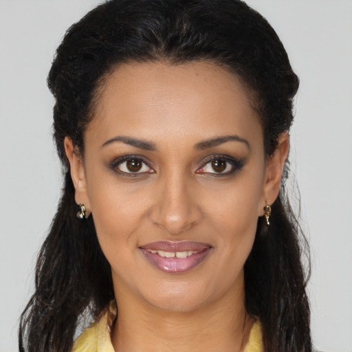 Joyful black young-adult female with long  brown hair and brown eyes