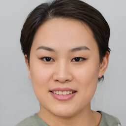 Joyful asian young-adult female with short  brown hair and brown eyes