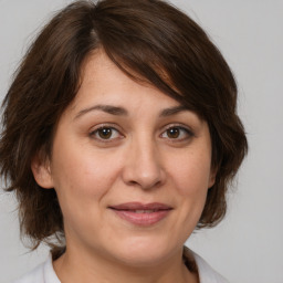 Joyful white adult female with medium  brown hair and brown eyes