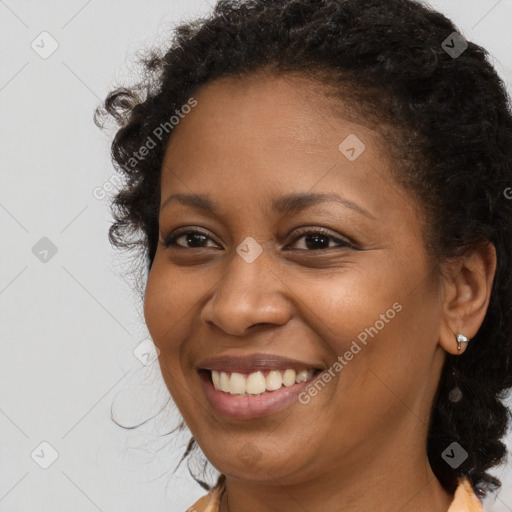 Joyful black young-adult female with long  brown hair and brown eyes