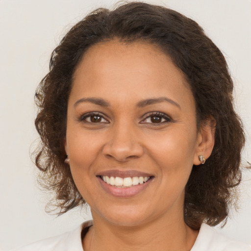 Joyful latino young-adult female with medium  brown hair and brown eyes