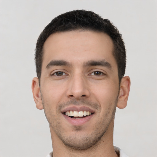 Joyful white young-adult male with short  black hair and brown eyes